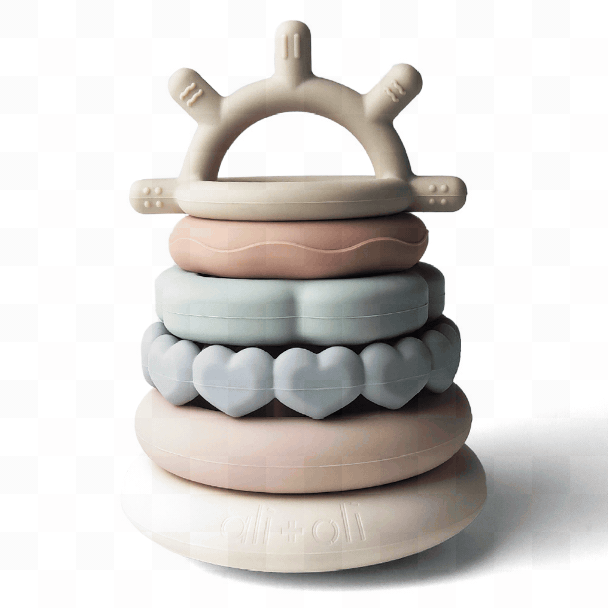 Stack of colorful silicone rings with a crown-shaped top on a white background