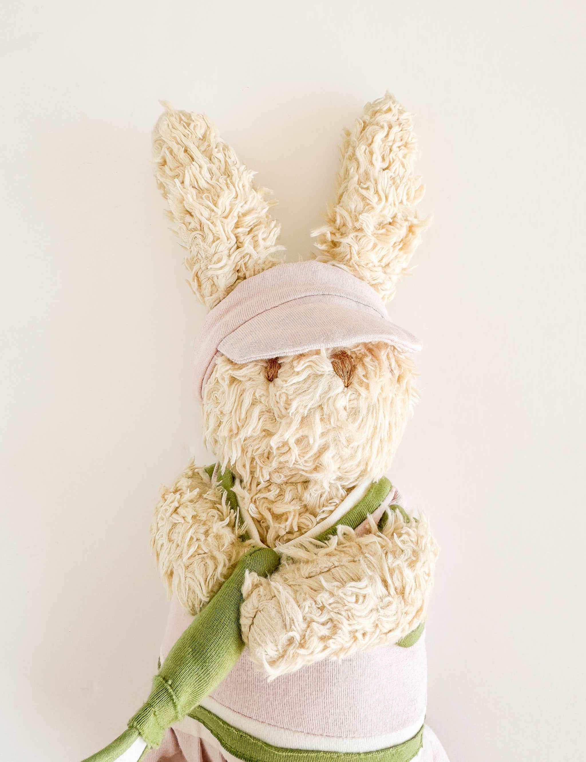 Ruby the Pickleball Bunny plush toy wearing a visor and tennis skirt, holding a plush pickleball paddle, made from organic cotton by The Blueberry Hill