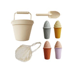 Retro-inspired silicone ice cream beach set with pastel-colored cones, ice cream tops, bucket, and shovel, all packed in a cotton storage bag for easy, on-the-go play.