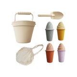 Retro-inspired silicone ice cream beach set with pastel-colored cones, ice cream tops, bucket, and shovel, all packed in a cotton storage bag for easy, on-the-go play.