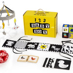 Baby product set including a yellow box labeled '123 Baby Box', toys, and educational items on a white background.
