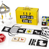 Baby product set including a yellow box labeled '123 Baby Box', toys, and educational items on a white background.
